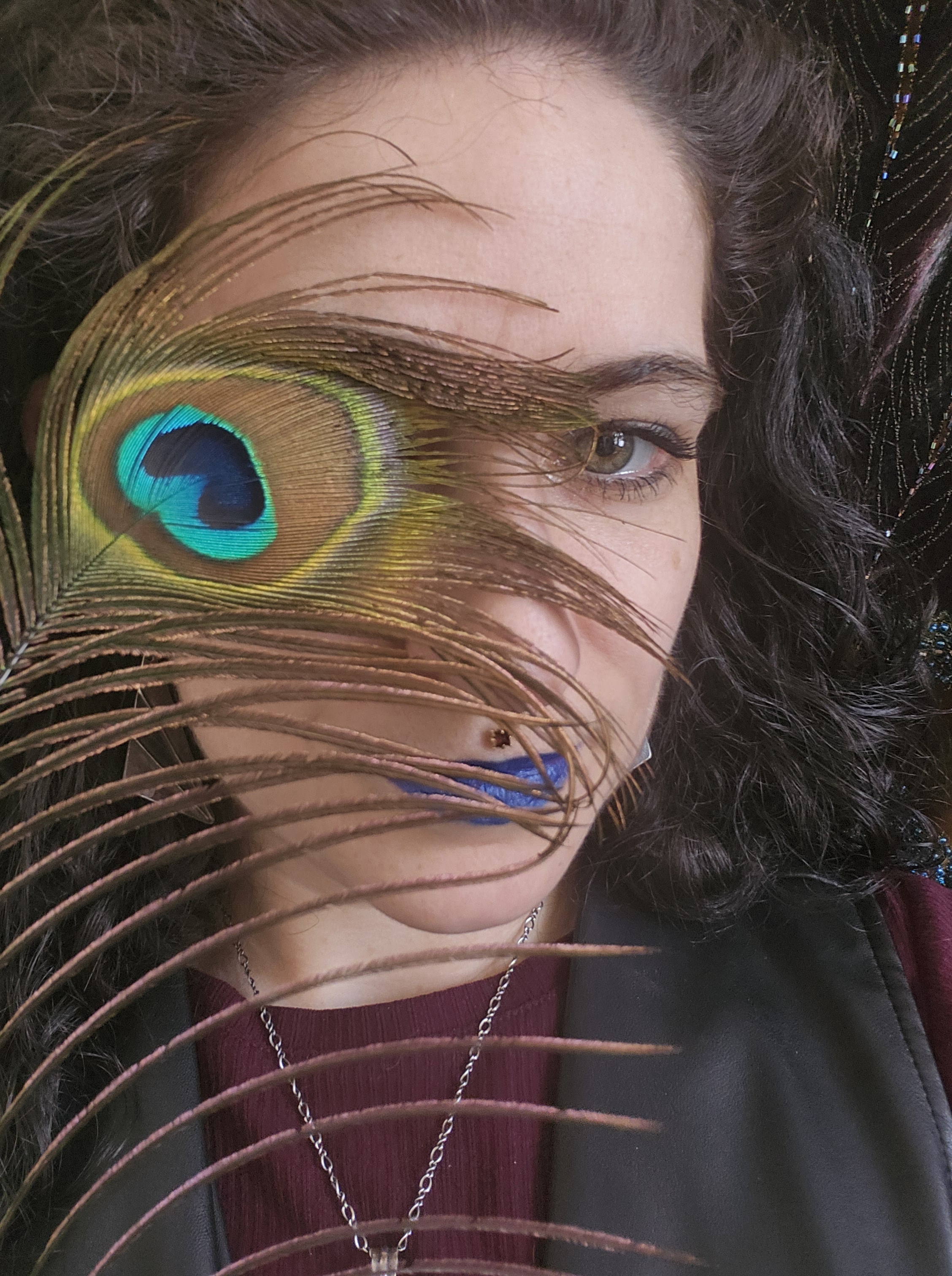 Raphael headshot with peacock feather covering half of their face